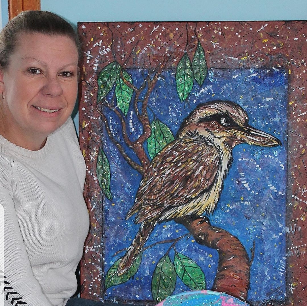 Woman poses with artwork of a Kookaburra